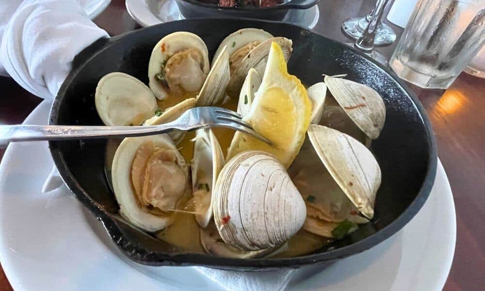 Steamed clams with lemon served in a cast iron skillet at Viera on Main in downtown Chatham, Massachusetts.