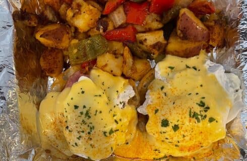 Fresh eggs benedict with homemade hash browns in a to go container