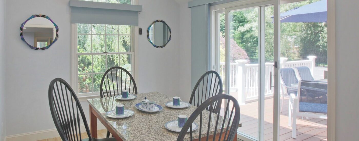 Dining room with large painting on the wall, bright window and table with tall rounded chairs